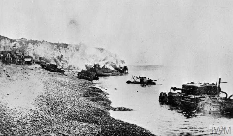 Burnt out tanks and landing craft lie strewn across the beach at Dieppe after the Allied withdrawal. © IWM. (HU 1905)